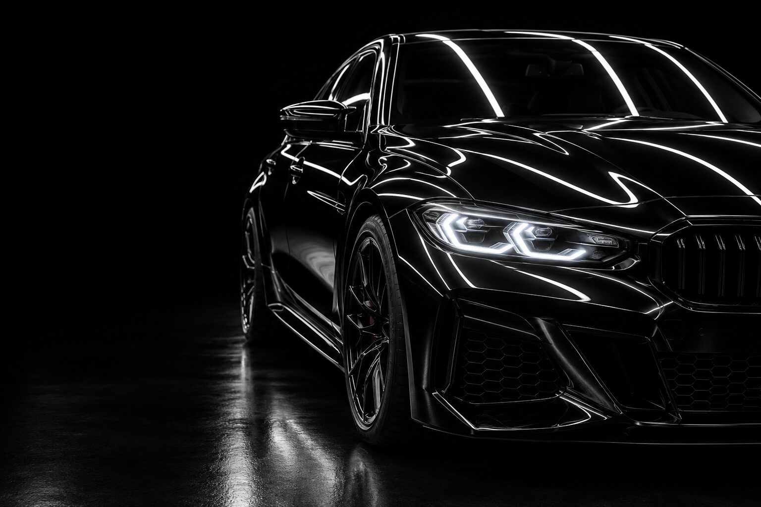 Glossy black ceramic-coated sedan in a dark studio