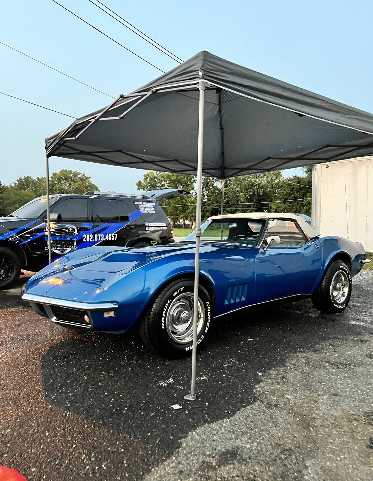 Classic blue Corvette detailed under a mobile canopy